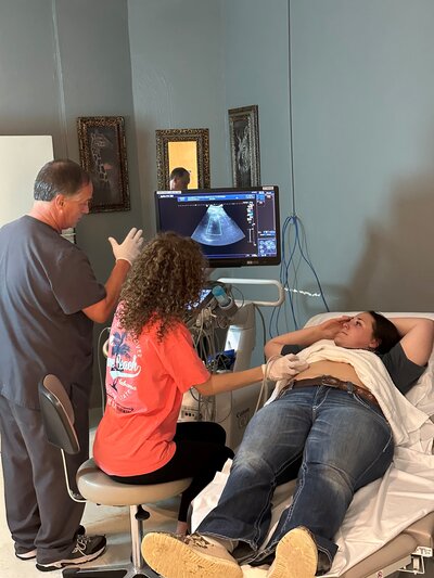 Patient receiving a ultrasound procedure in a hospital room.